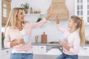Frazy, które warto mówić swojemu dziecku Mother-daughter-holding-mugs-saluting